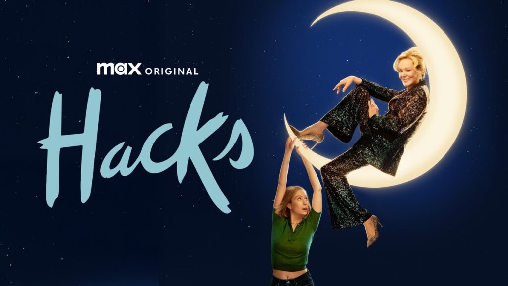 Onde assistir às séries vencedoras do Emmy 2025 6 Deborah Vance (Jean Smart) sentada em uma lua iluminada enquanto Ava Daniels (Hannah Einbinder) a segura por baixo, no pôster da série Hacks, da HBO Max.