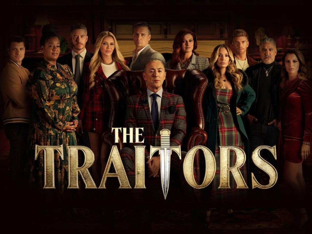 Onde assistir às séries vencedoras do Emmy 2025 10 Elenco reunido em frente a uma sala luxuosa com Alan Cumming ao centro como apresentador, na série de reality The Traitors, do Prime Video.