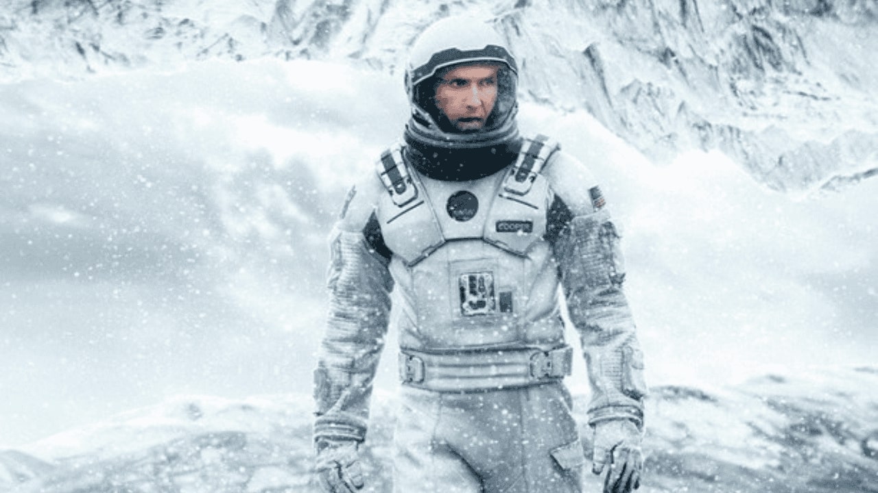 Melhores filmes de ficção científica da Netflix para assistir agora 1 Cena do filme Interestelar, explorador espacial em traje branco em meio a uma tempestade gelada.