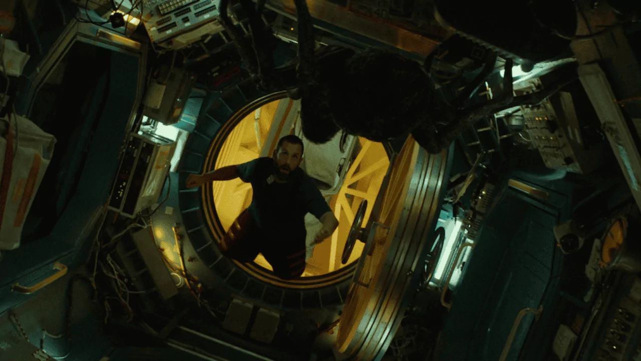 Melhores filmes de ficção científica da Netflix para assistir agora 2 Cena do filme O Astronauta. Jakub, personagem de Adam Sandler, está dentro de uma estação espacial observa uma criatura escura e ameaçadora